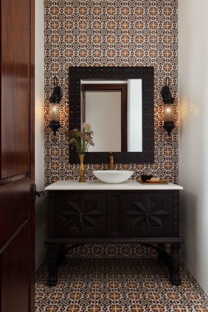 Spanish style tile bathroom with dark wood, handcrafted vanity. Marble countertop with white vessel sink.