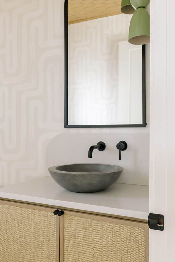 A NativeStone concrete sink set against a playful, geometric wallpaper