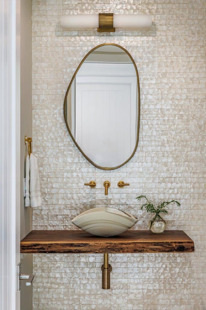 Murano Glass Sink set against a mother of pearl tile backsplash and a live edge wood countertop
