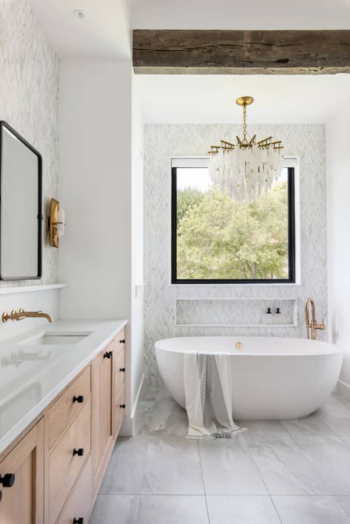 concrete freestanding bathtub and white marble tile backsplash