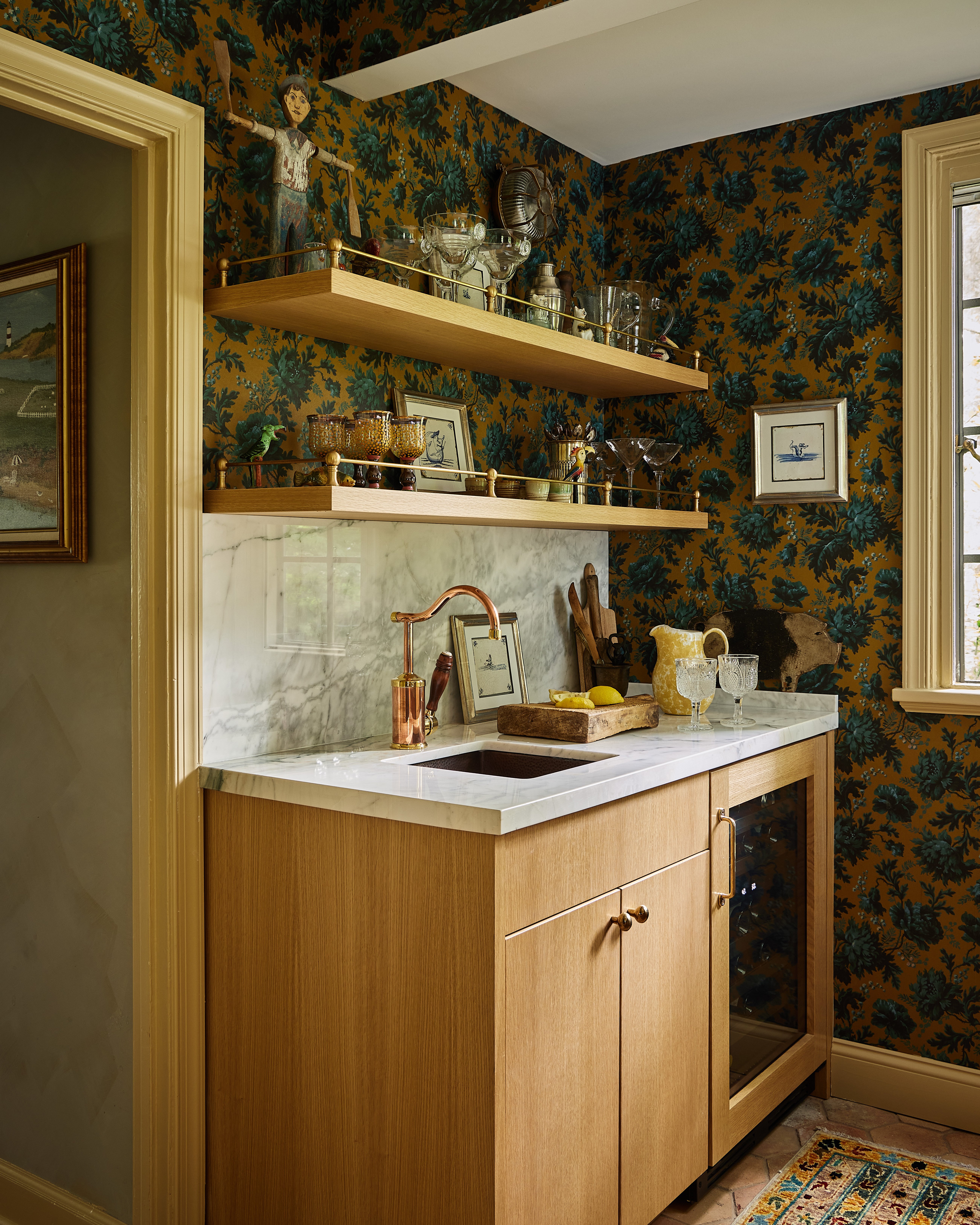 An eclectic kitchen design with vibrant floral wallpaper featuring a Native Trails copper bar sink and copper faucet