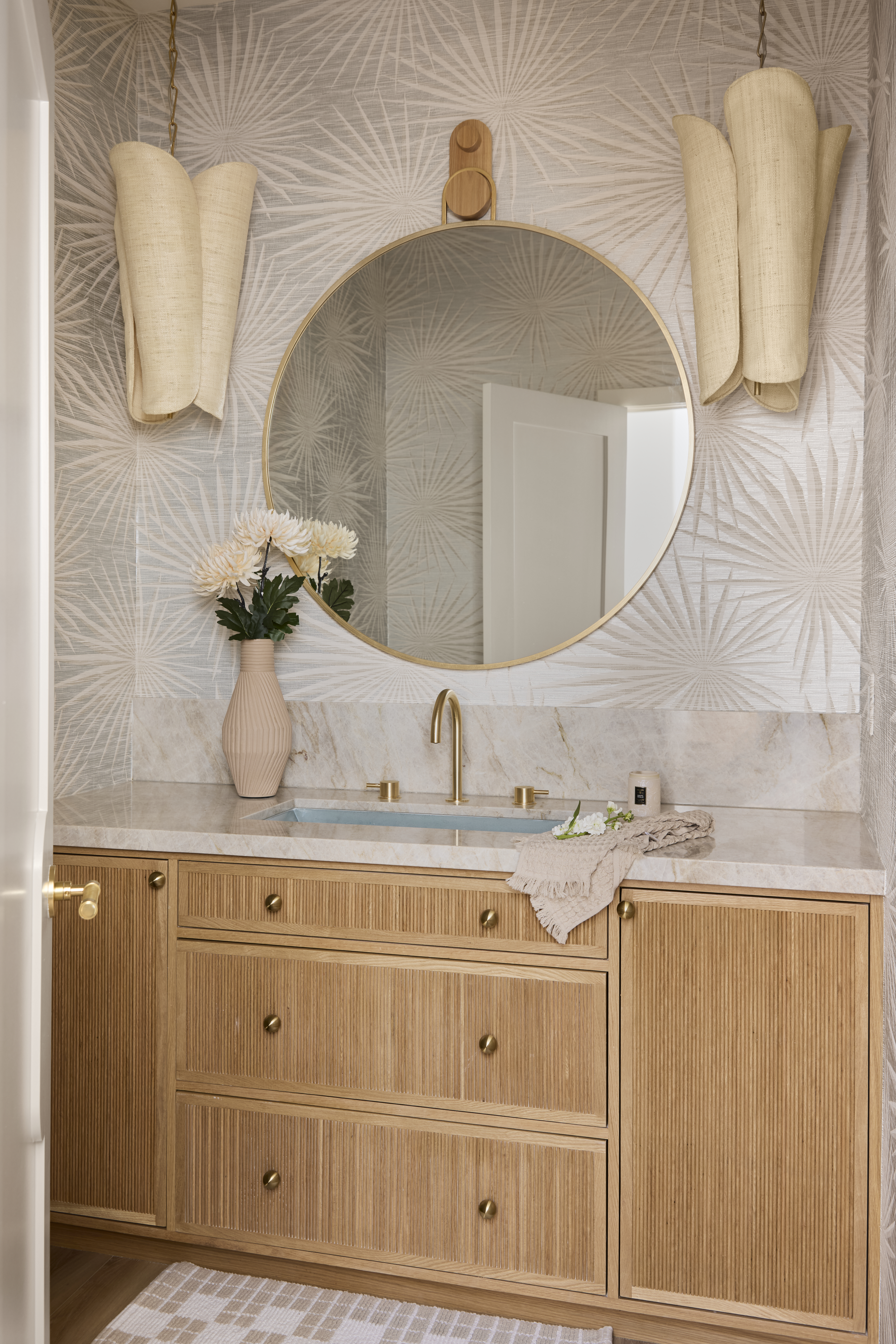 Hermosa Beach, CA designer places blue sink in powder room with dramatic lighting and white oak cabinetry and vibrant wallpaper