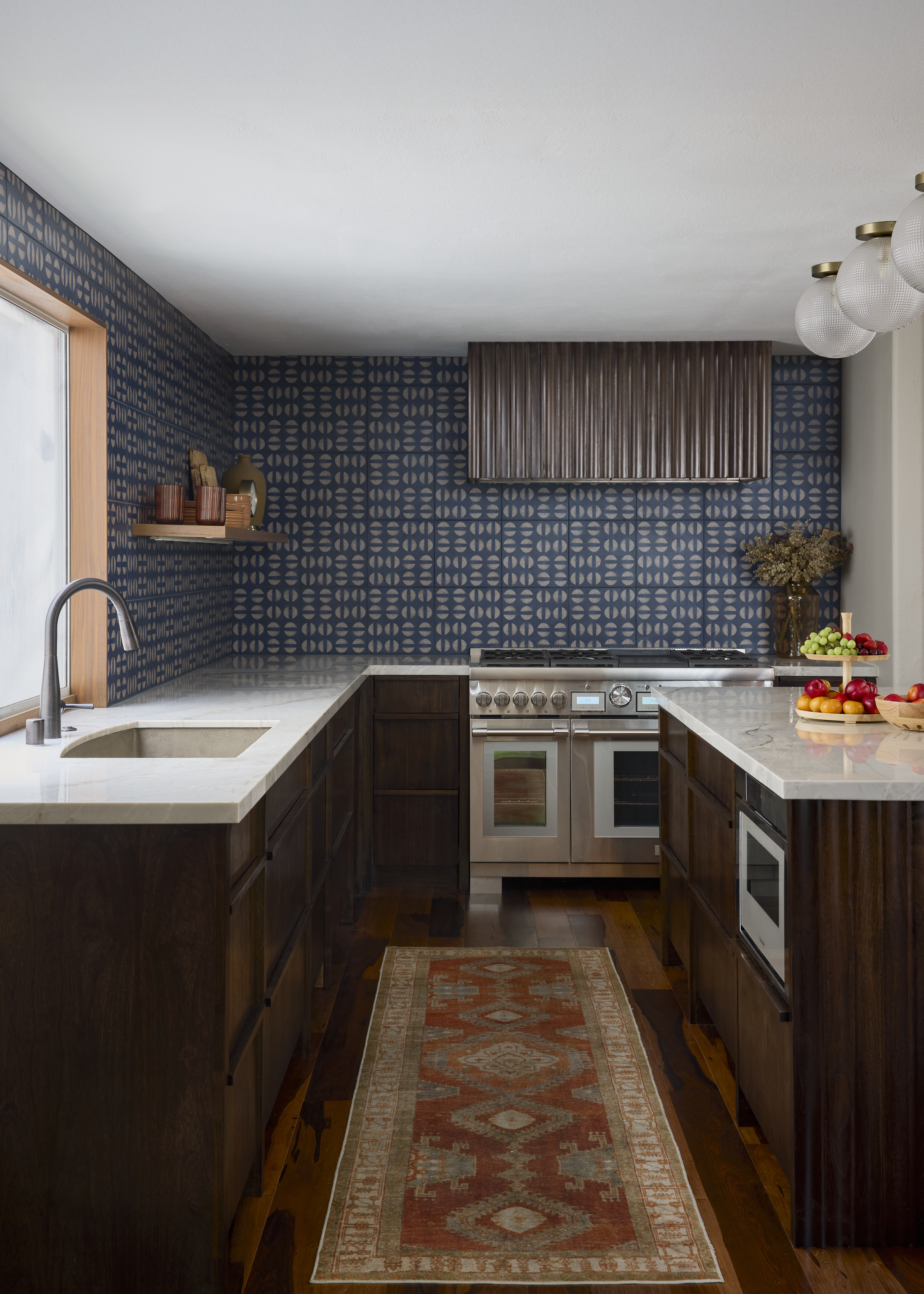 Kitchen with southwest style rug, colorful tile wall and warm walnut wood cabinets and a Native Trails concrete kitchen sink