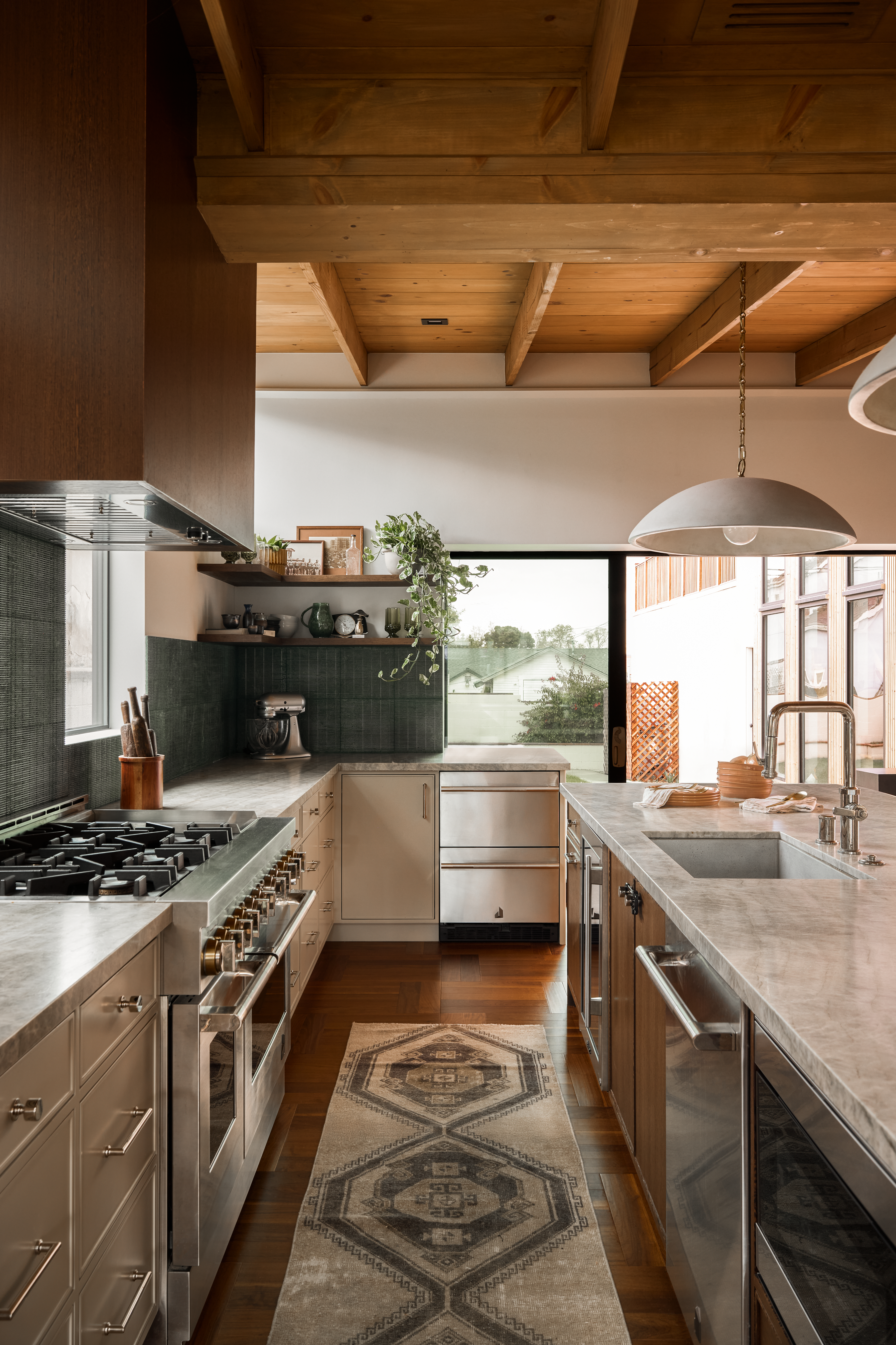 Color tile backsplash in kitchen with raw edged Taj Mahal quartzite countertops and undermount concrete kitchen sink