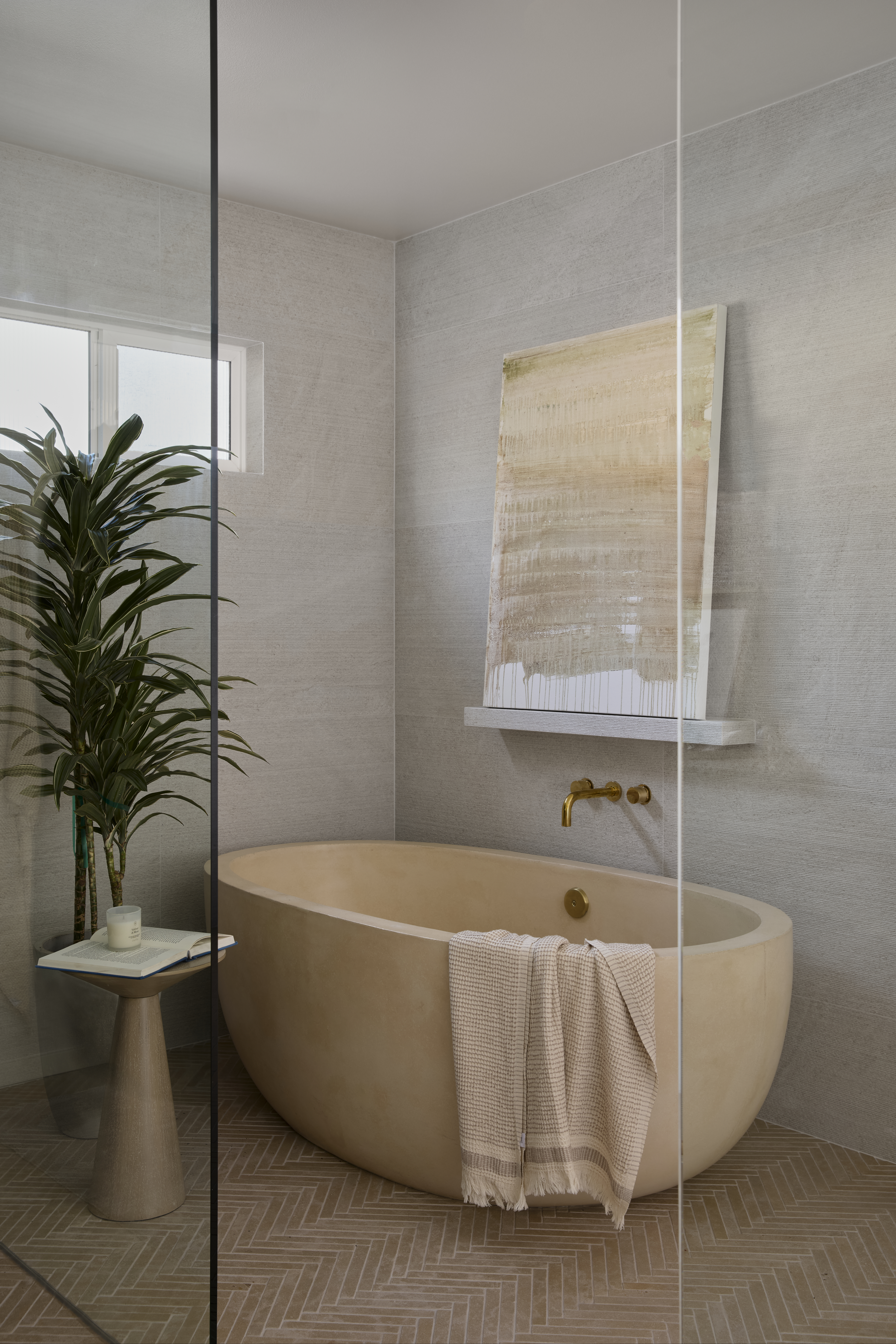 Sand colored concrete bathtub with chevron tile floor
