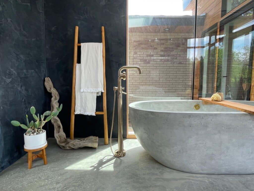 Concrete bathtub featured in a large bedroom
