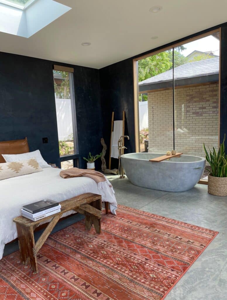 Concrete bathtub featured in a large bedroom