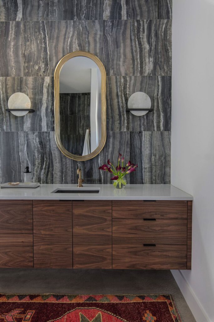 Eclectic interior design takes center stage with warm wood cabinets and a natural stone wall